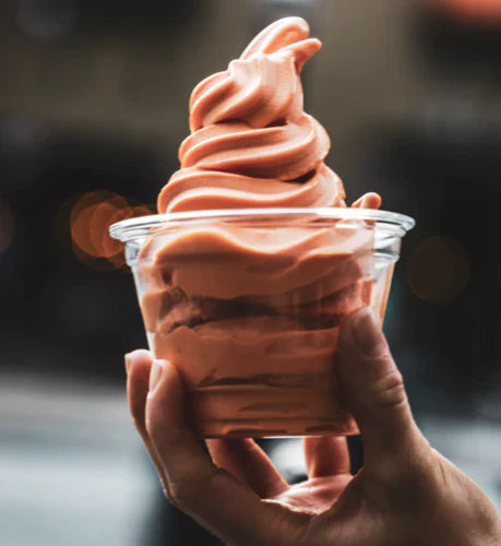 A clear plastic cup of vegan soft serve ice cream