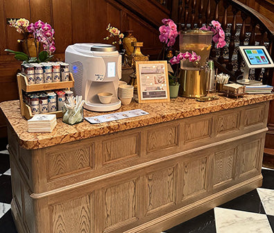 A table displaying a ColdSnap machine, ColdSnap Pods, cups, and decorative elements in a fancy venue. 