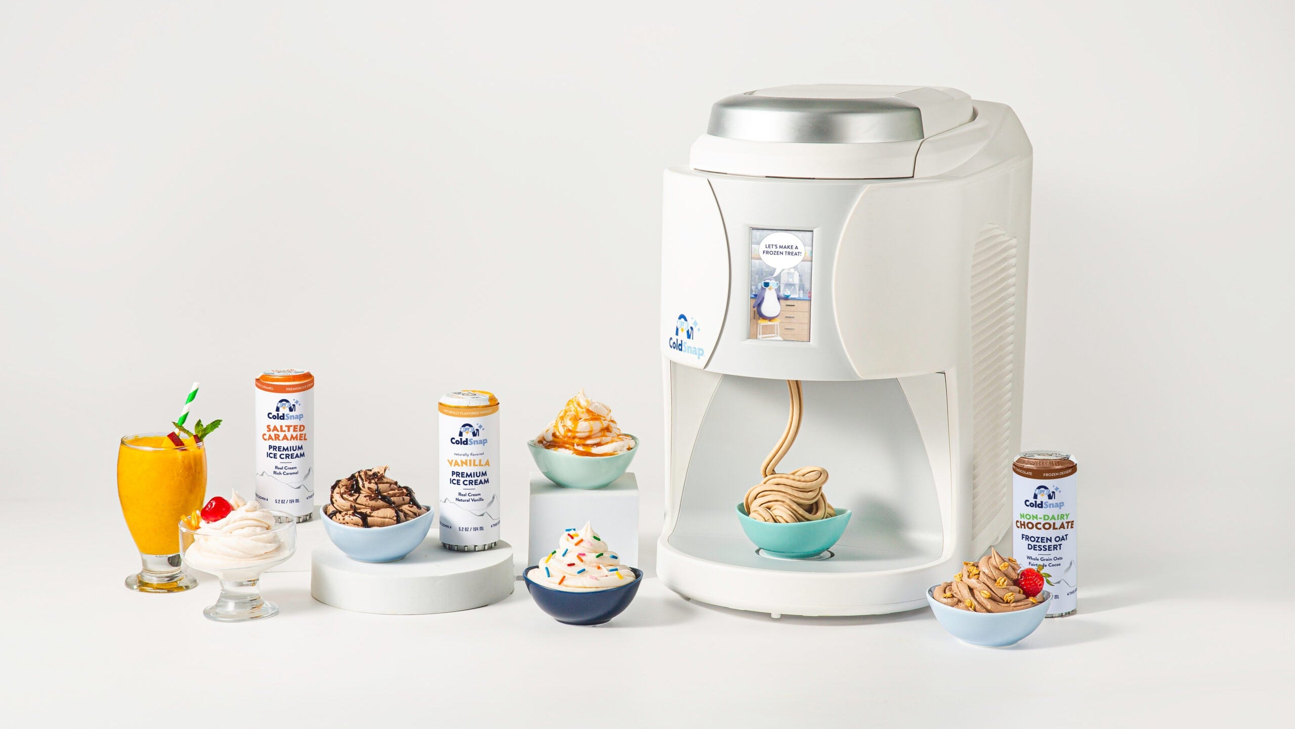ColdSnap® Frozen Treat Machine, surrounded by various treat pods and ice cream bowls