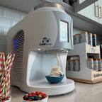 ColdSnap® frozen treat machine sitting on a kitchenette counter next to a ColdSnap® pod display rack and toppings
