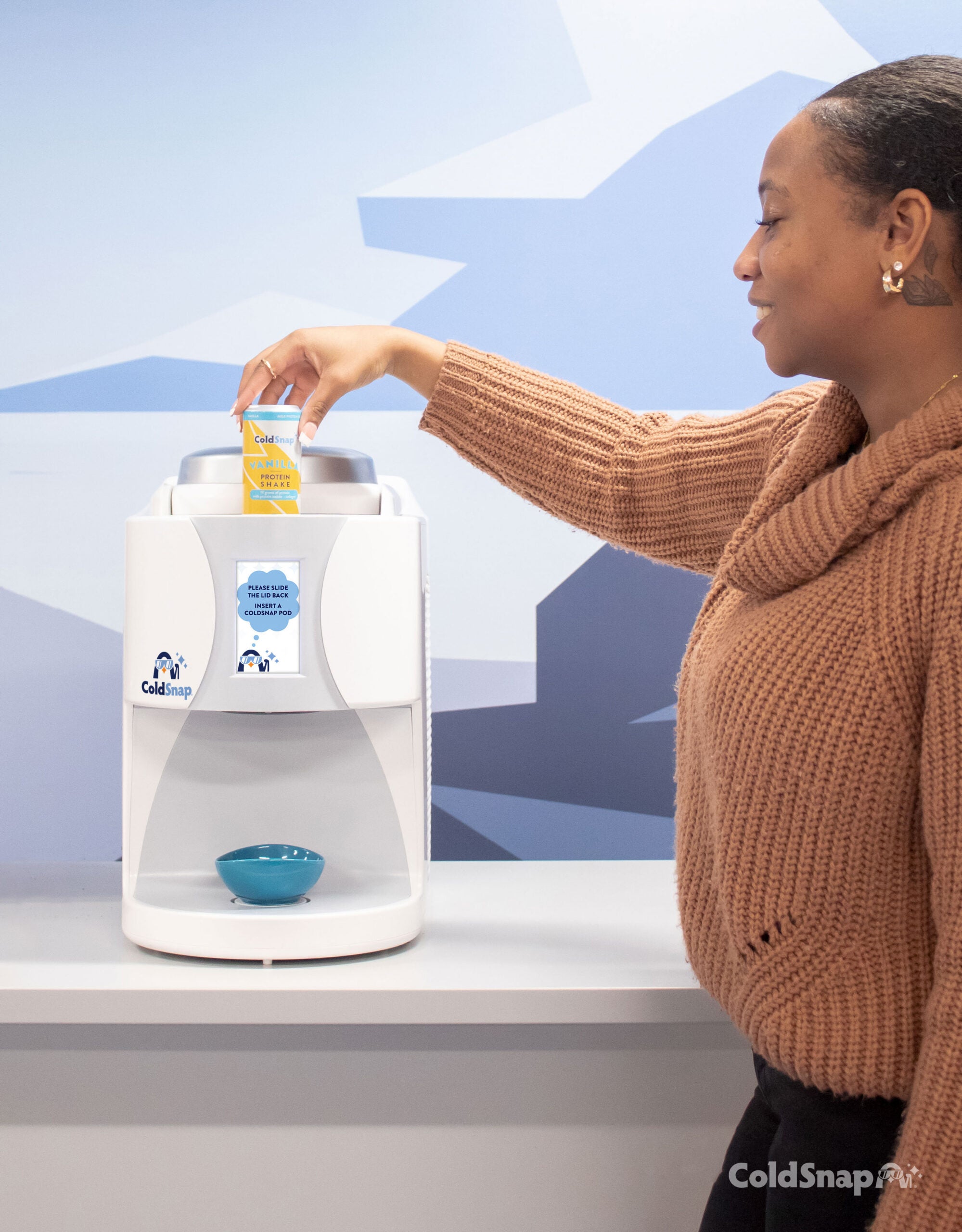 A person inserted a ColdSnap Protein Shake pod into a ColdSnap machine. 