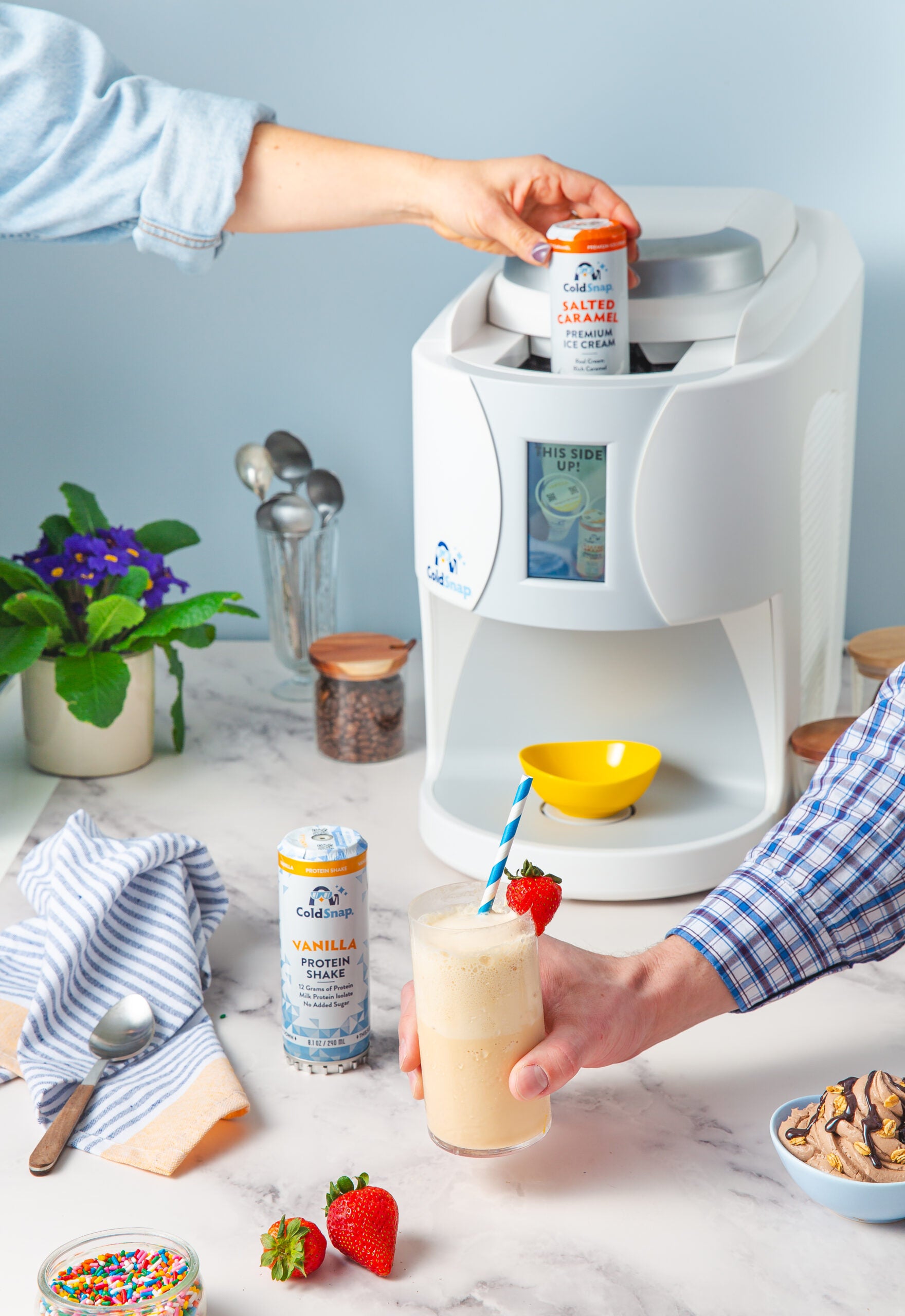 Person making a ColdSnap beverage by inserting a ColdSnap pod into a ColdSnap machine. 