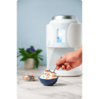 Hand scooping some ColdSnap® Vanilla Premium Ice Cream with sprinkles from a blue bowl