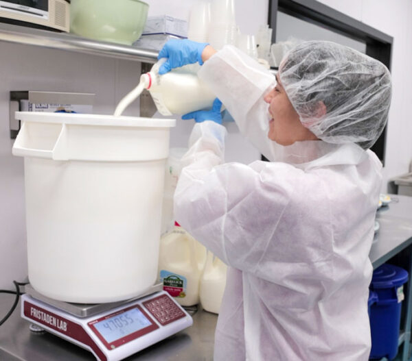 Lead Food Scientist at ColdSnap pours milk for ColdSnap's ice cream mix